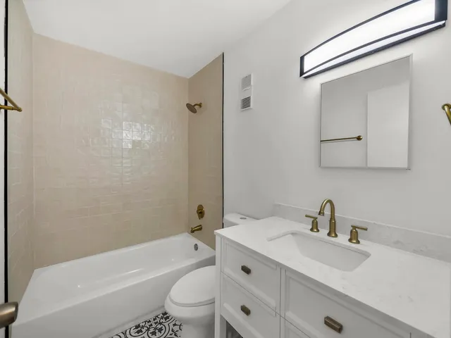 a bathroom with a sink toilet a mirror and shower