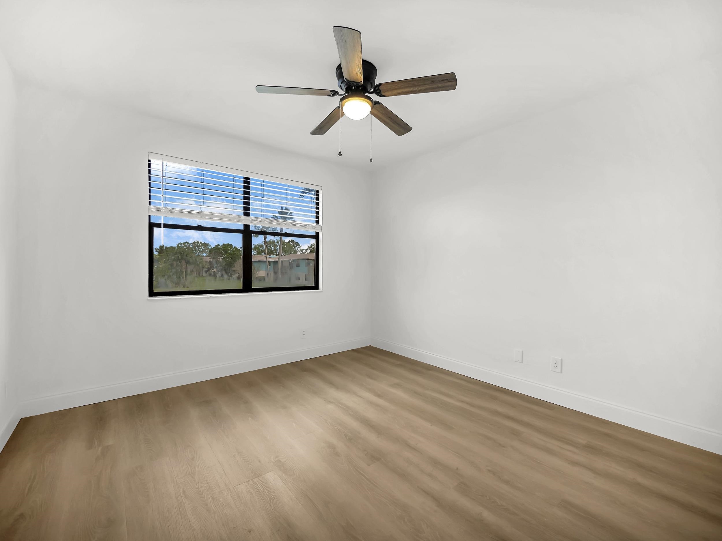 650 West Pope Road, Unit 218 St. Augustine, FL 32080 - Photo 19 of 30 an empty room with wooden floor ceiling fan and windows