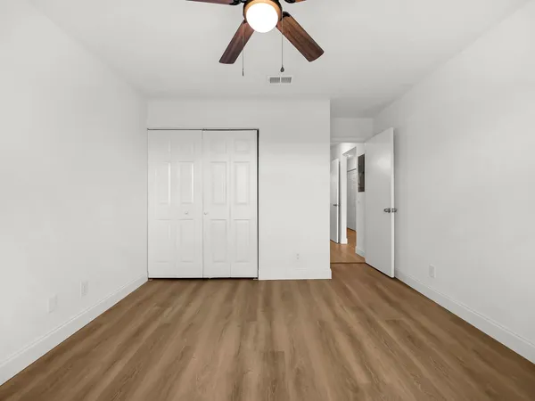 a view of empty room with wooden floor