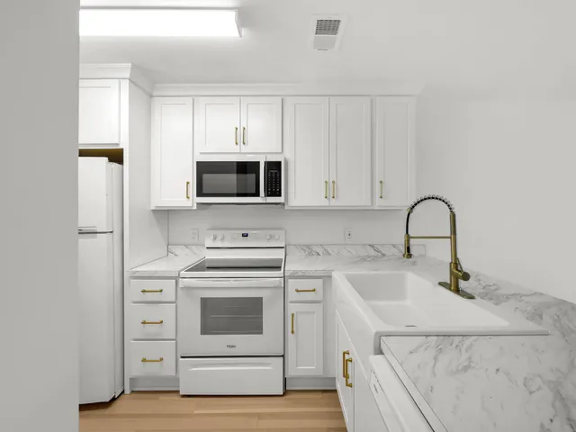 a kitchen with white cabinets stainless steel appliances and sink