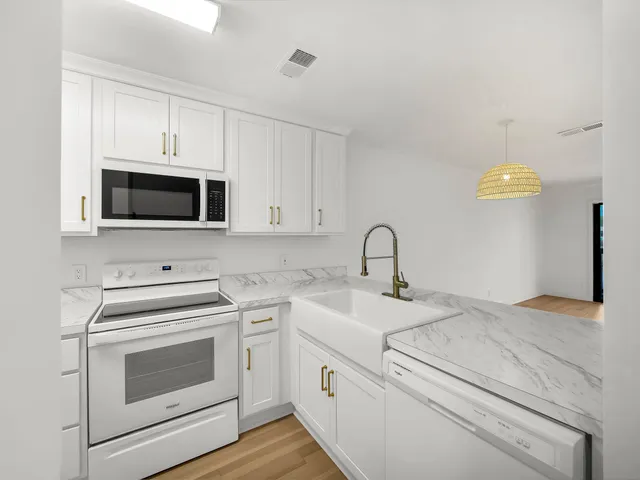 a kitchen with white cabinets stainless steel appliances and sink