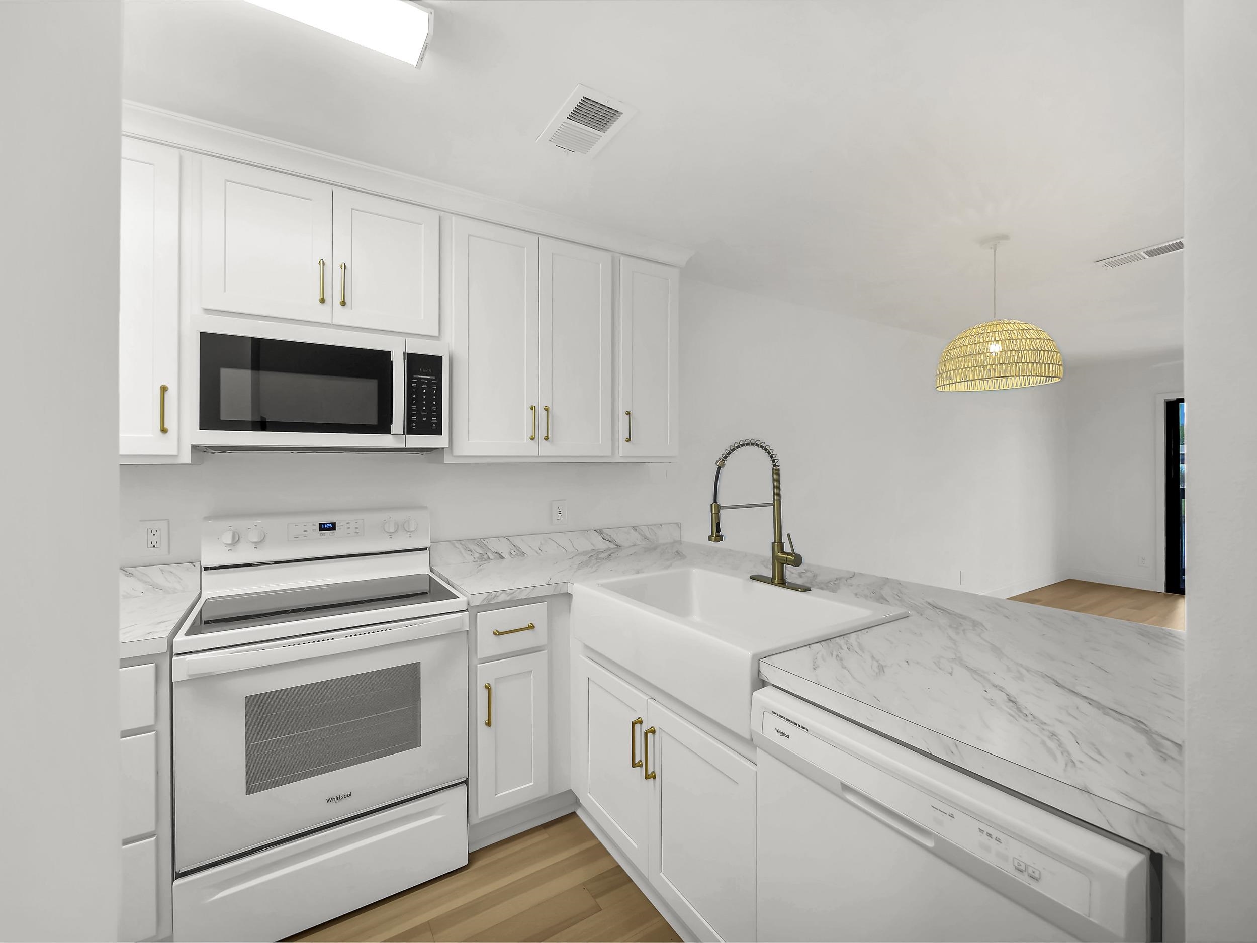650 West Pope Road, Unit 218 St. Augustine, FL 32080 - Photo 5 of 30 a kitchen with white cabinets stainless steel appliances and sink