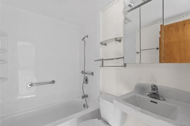 a bathroom with a tub a sink and mirror