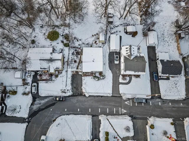 a view of white house with a yard covered in snow