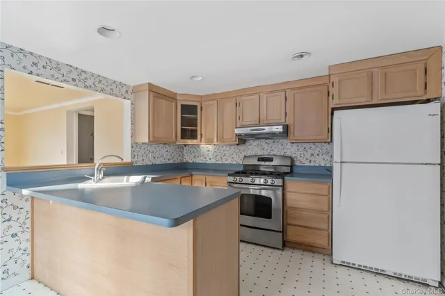 a kitchen with stainless steel appliances granite countertop a sink stove and refrigerator