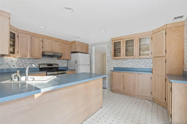 a large kitchen with granite countertop a lot of counter space and cabinets