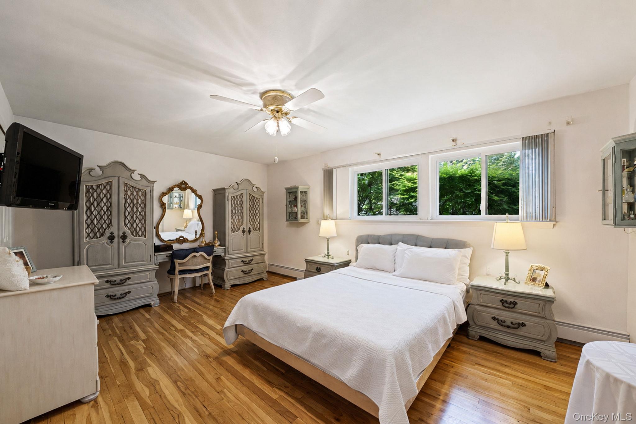 96 Fulton Boulevard Commack, NY 11725 - Photo 37 of 41 a bedroom with a bed a chandelier and dresser