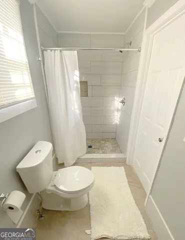 a bathroom with a toilet and a shower