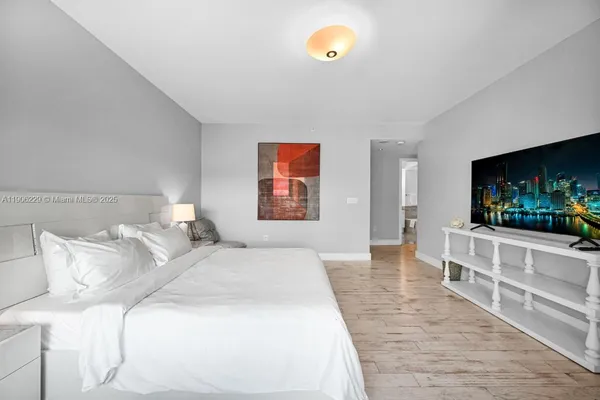 a bedroom with a bed and a flat screen tv
