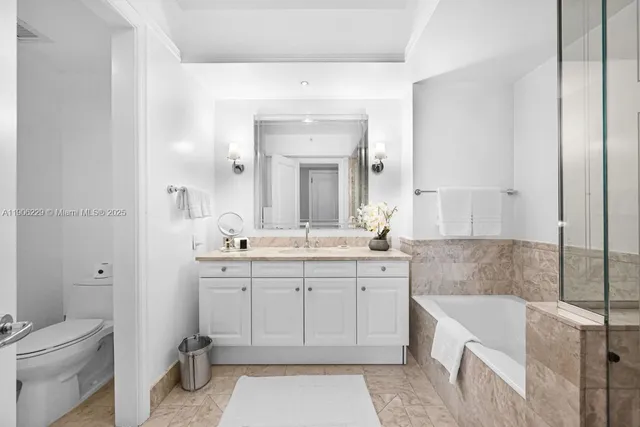 a spacious bathroom with a tub sink shower and mirror