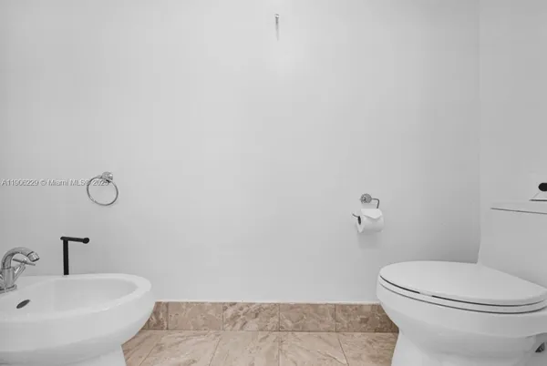 a white toilet sitting next to a white sink