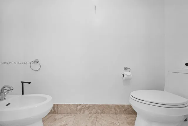 a white toilet sitting next to a white sink
