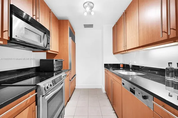 a kitchen with stainless steel appliances granite countertop a sink a stove and a microwave