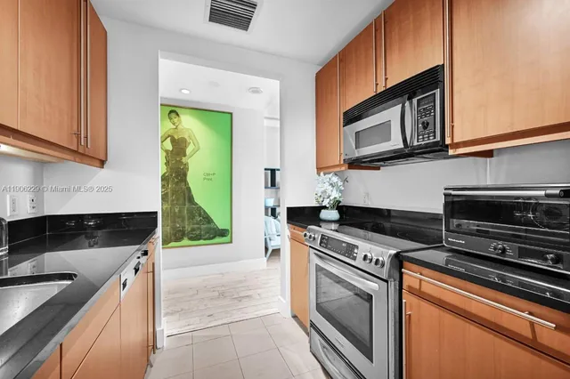 a kitchen with granite countertop a stove microwave and sink