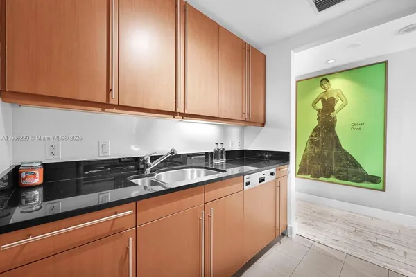 a kitchen with granite countertop white cabinets and sink