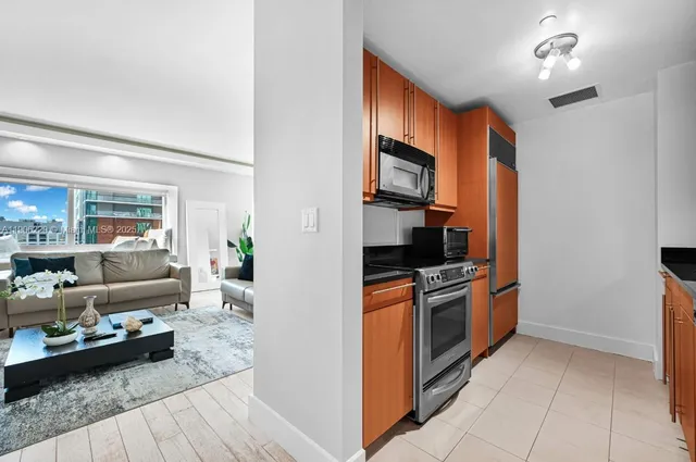 a kitchen with stainless steel appliances granite countertop a refrigerator and a stove top oven