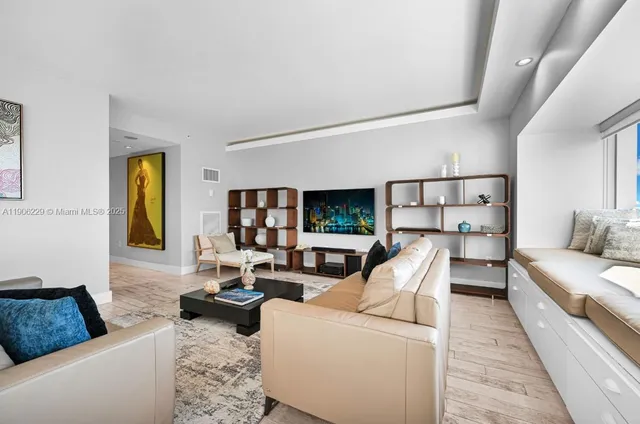 a living room with furniture fireplace and a large window