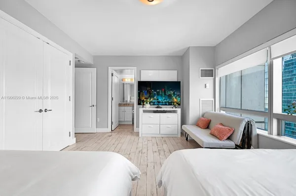 a bedroom with furniture and a large window