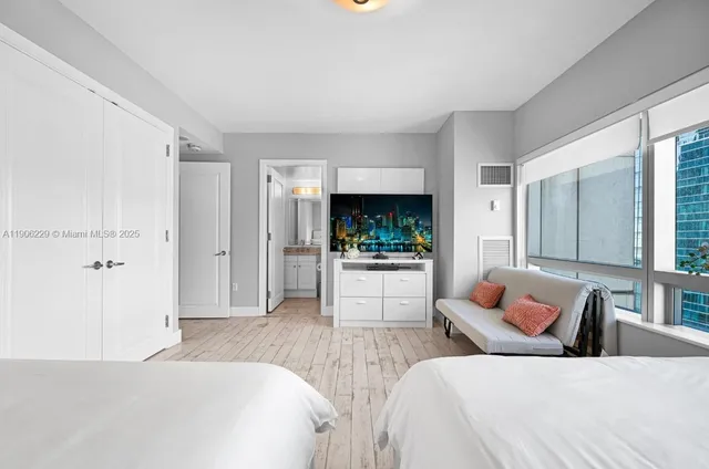 a bedroom with furniture and a large window