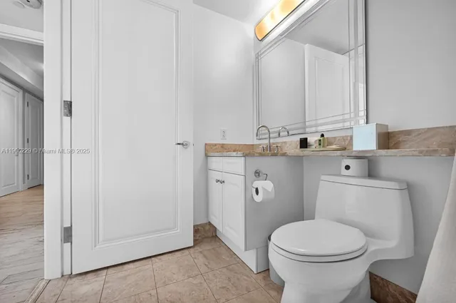 a bathroom with a toilet a sink and mirror