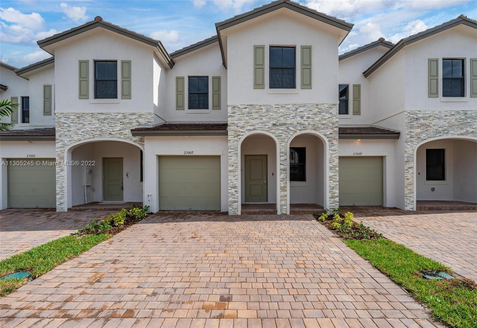 a front view of a house with yard and parking