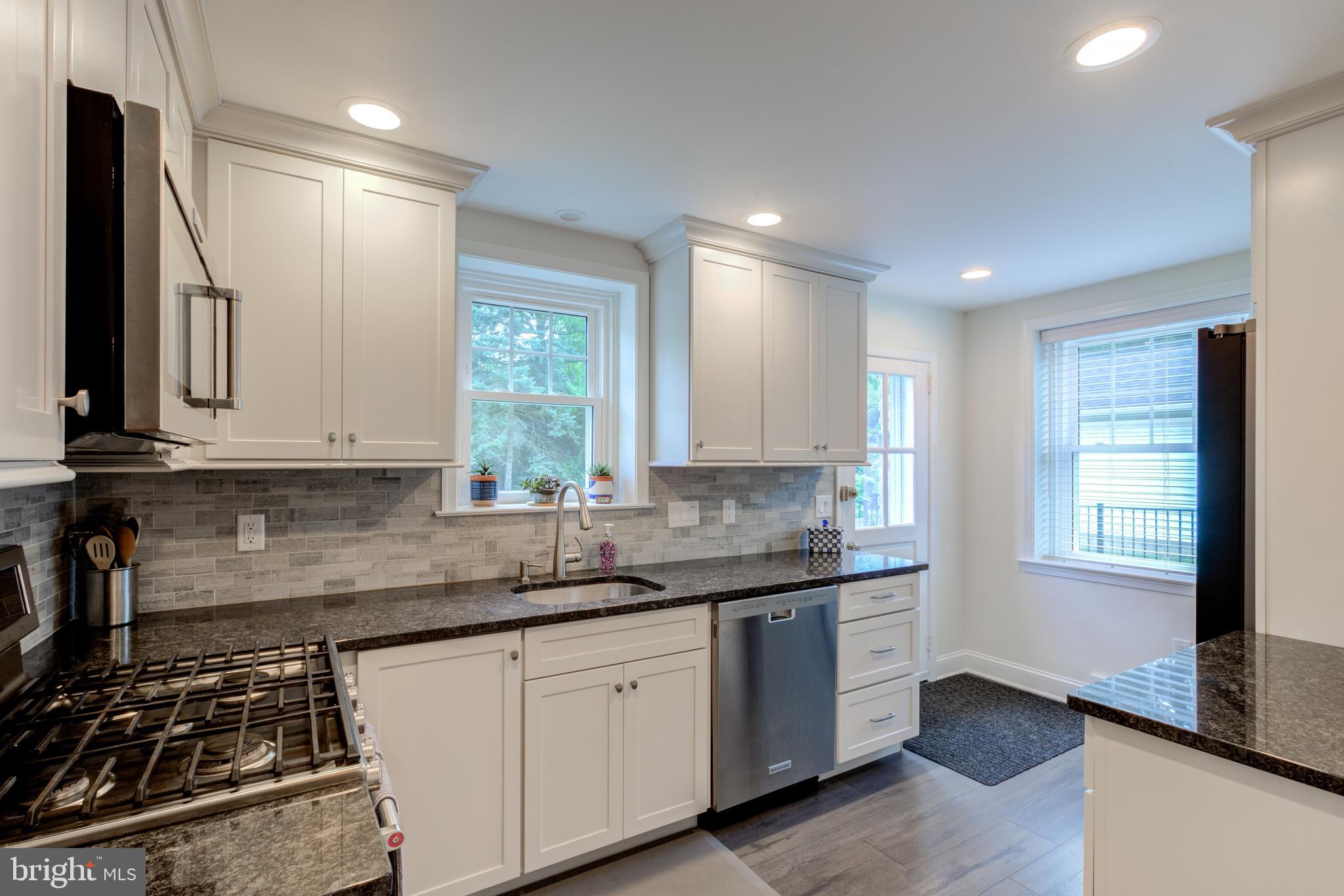 51 Mansion Road Springfield, PA 19064 - Photo 17 of 45 a kitchen with granite countertop white cabinets stainless steel appliances a sink and a window