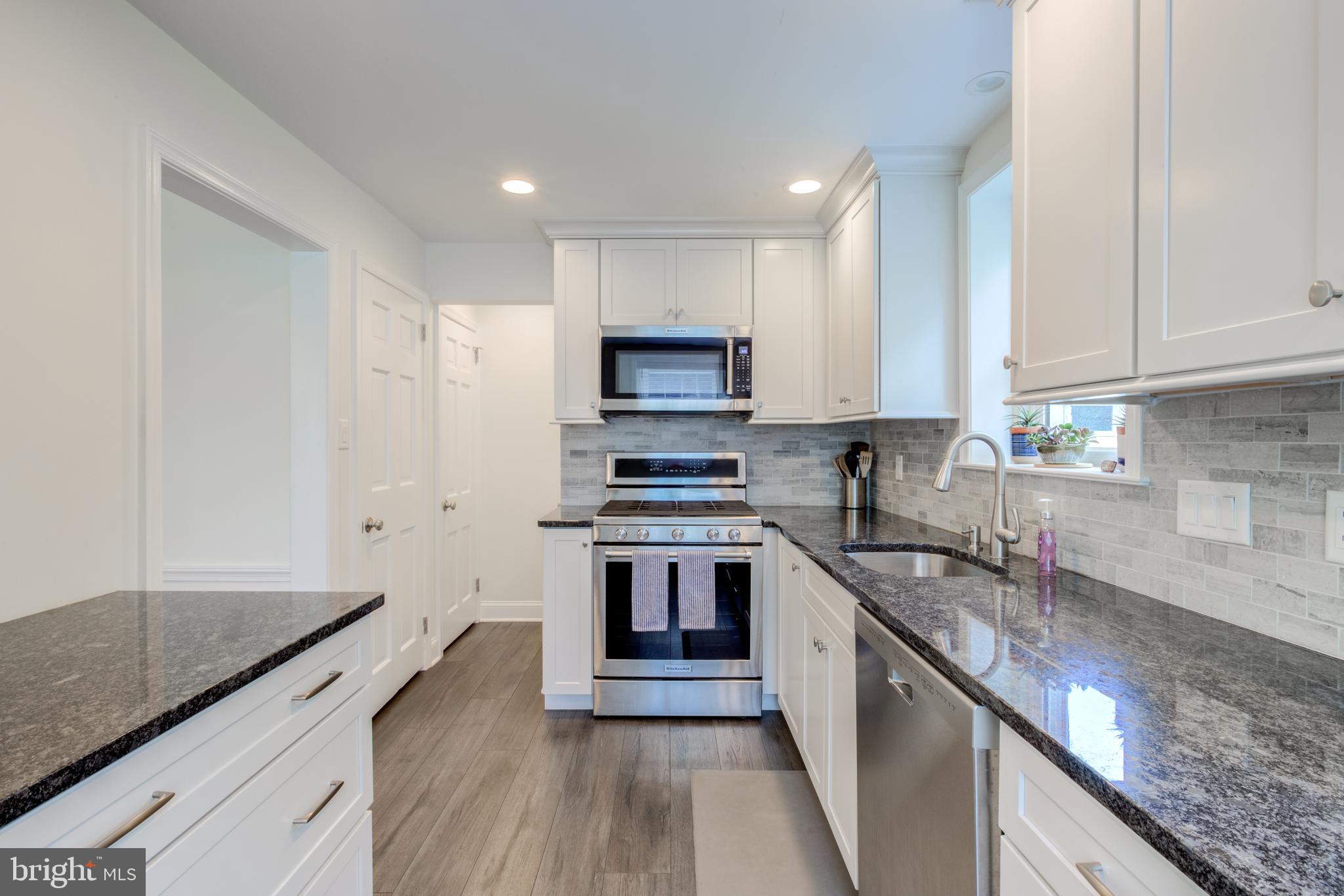 51 Mansion Road Springfield, PA 19064 - Photo 19 of 45 a kitchen with stainless steel appliances granite countertop a stove and a sink