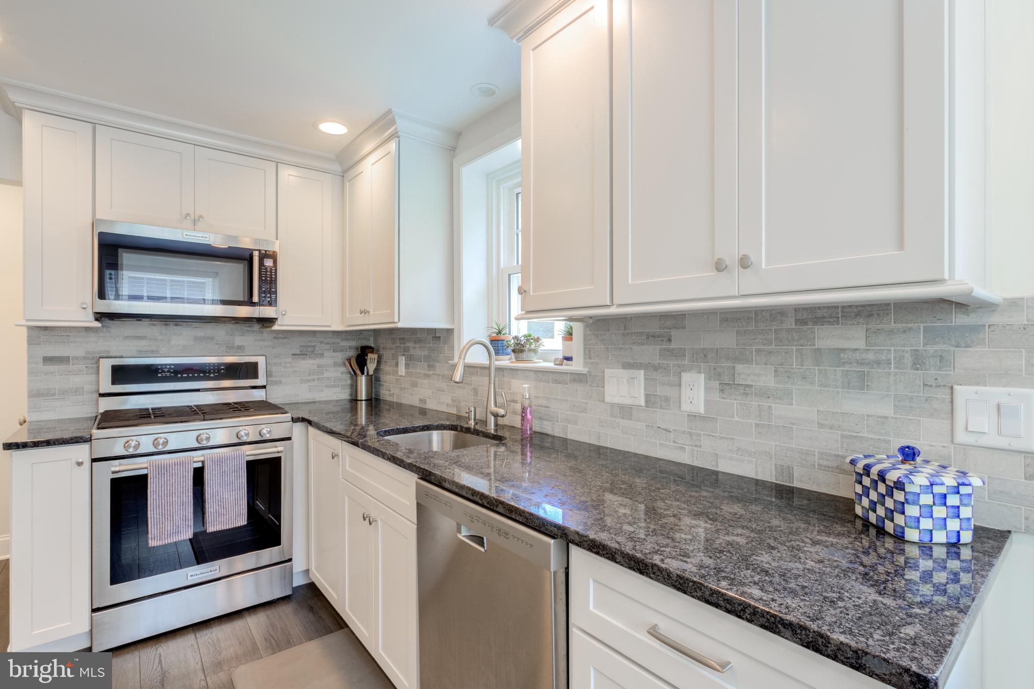 51 Mansion Road Springfield, PA 19064 - Photo 20 of 45 a kitchen with stainless steel appliances granite countertop a sink stove and microwave