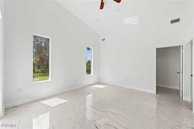 a view of an empty room with window and a bathroom