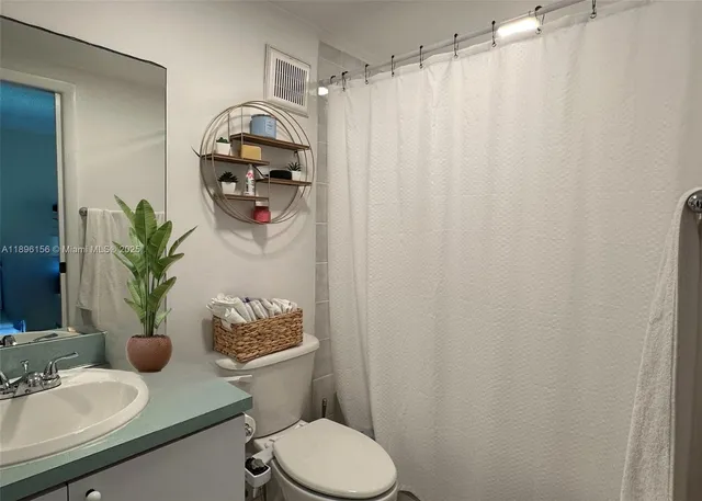 a bathroom with a sink toilet and mirror