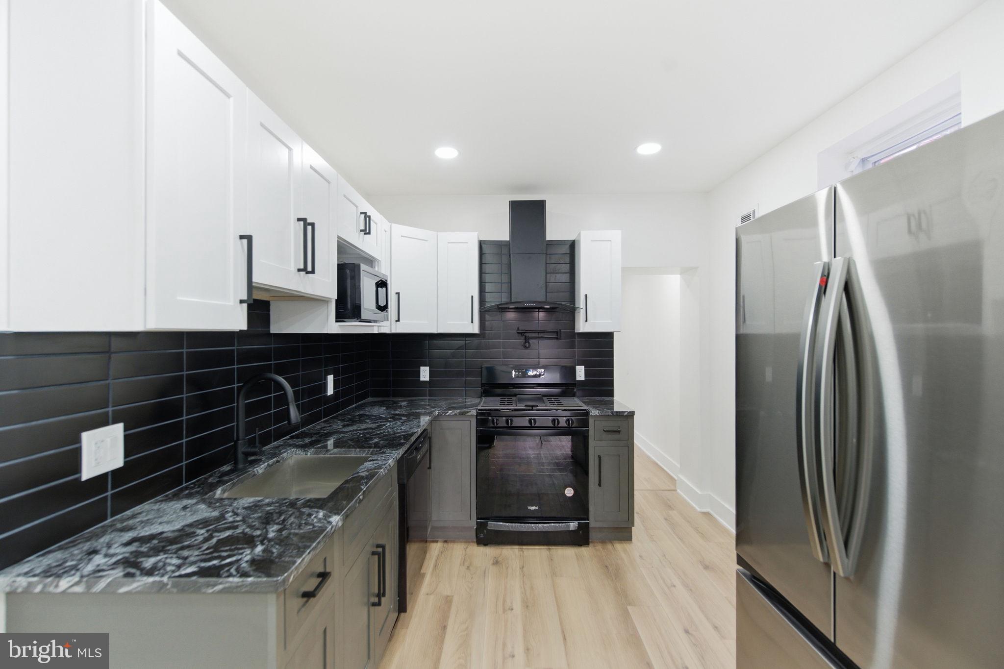 4662 James Street Philadelphia, PA 19137 - Photo 7 of 32 a kitchen with stainless steel appliances granite countertop a refrigerator a stove and a sink with wooden floor