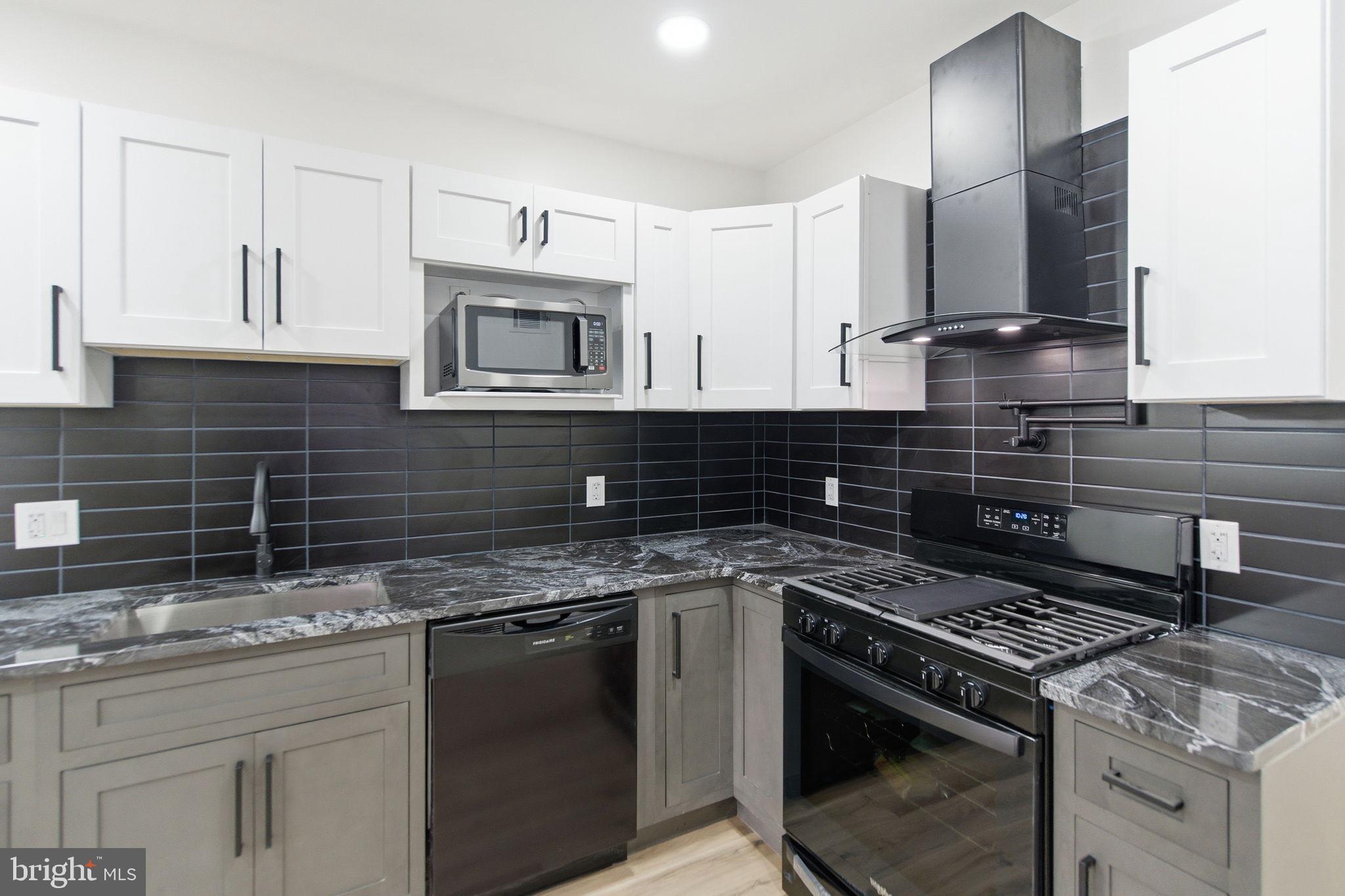 4662 James Street Philadelphia, PA 19137 - Photo 9 of 32 a kitchen with granite countertop a stove sink and cabinets