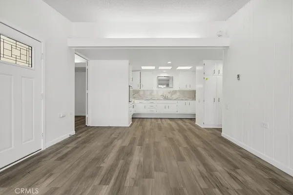 a kitchen with granite countertop white cabinets and white appliances