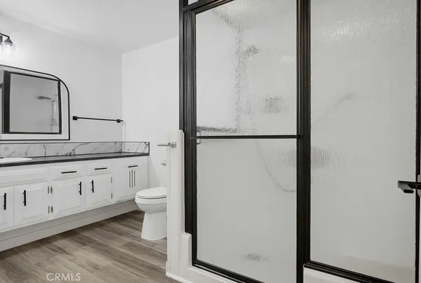 a bathroom with a granite countertop sink a toilet and a mirror