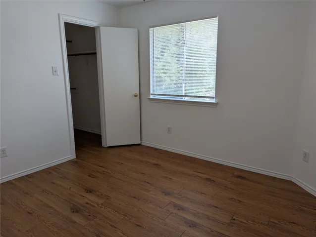an empty room with wooden floor and a window