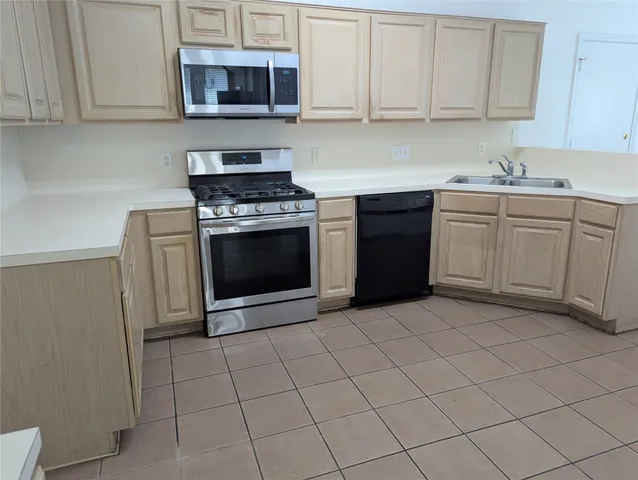 a kitchen with cabinets stainless steel appliances and a sink