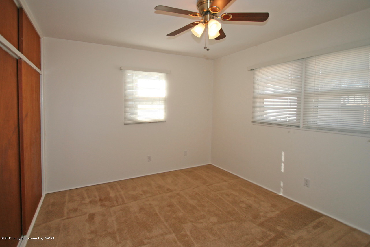 5106 Bowie Street Amarillo, TX 79110 - Photo 6 of 14 an empty room with a window and a chandelier fan