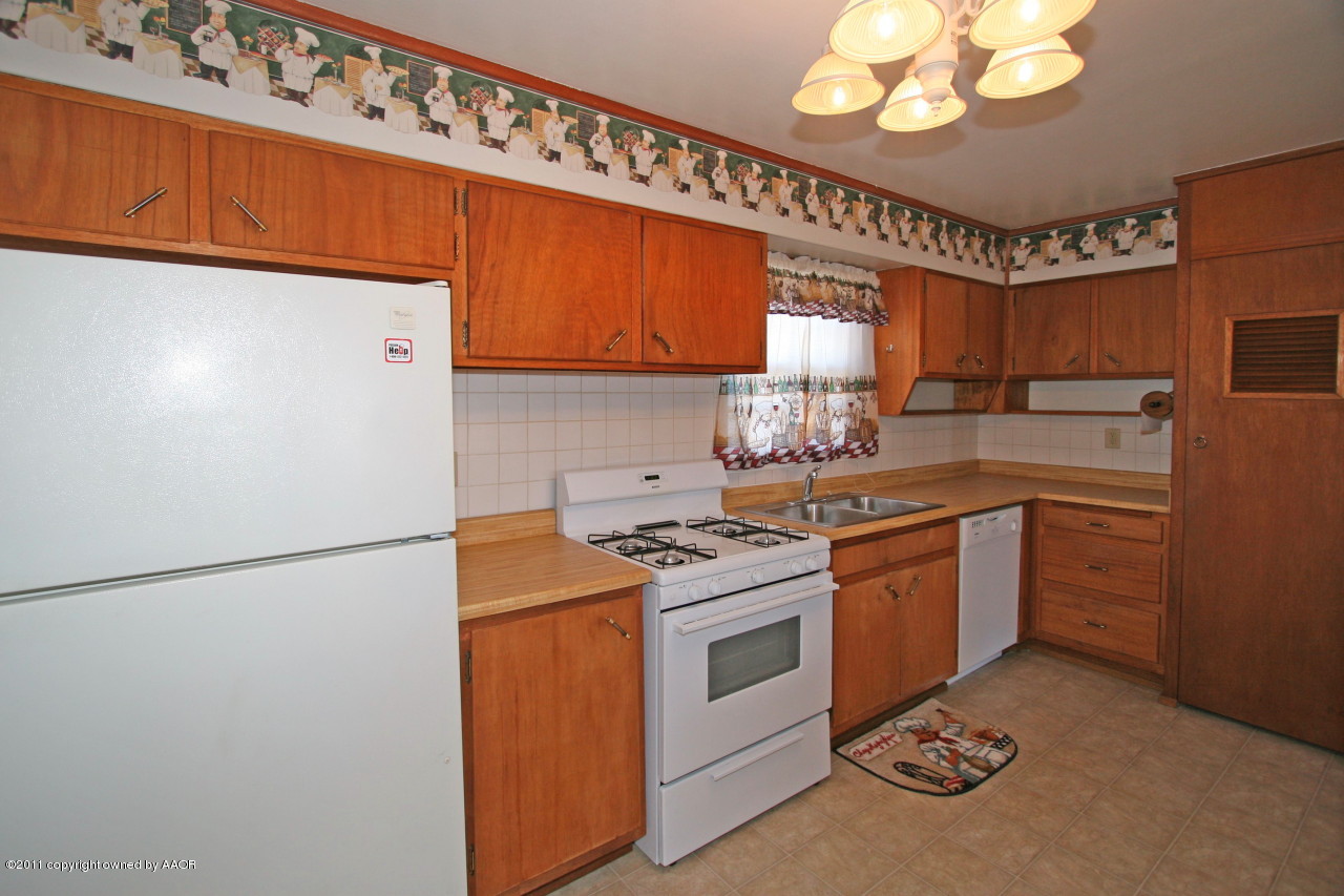 5106 Bowie Street Amarillo, TX 79110 - Photo 8 of 14 a kitchen with a sink a stove cabinets and stainless steel appliances