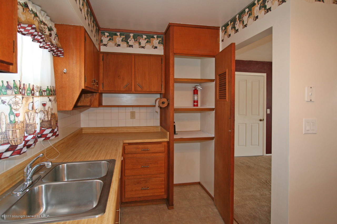 5106 Bowie Street Amarillo, TX 79110 - Photo 9 of 14 a kitchen with a sink and a refrigerator