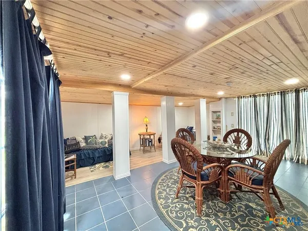 a dining room with furniture and a floor to ceiling window