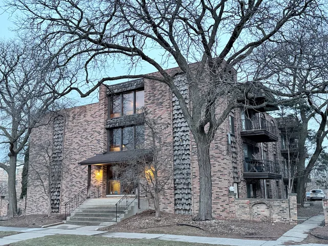 a front view of a house with a tree