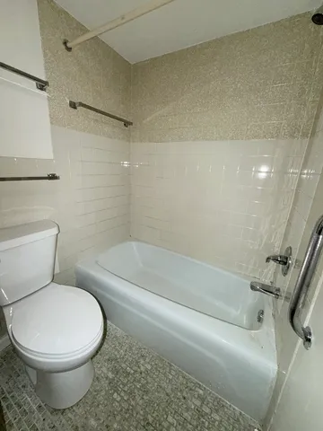 a white toilet and tub sitting next to a bathroom sink