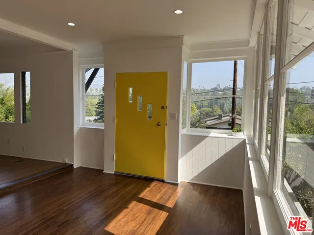a view of a hallway with wooden floor and a living room