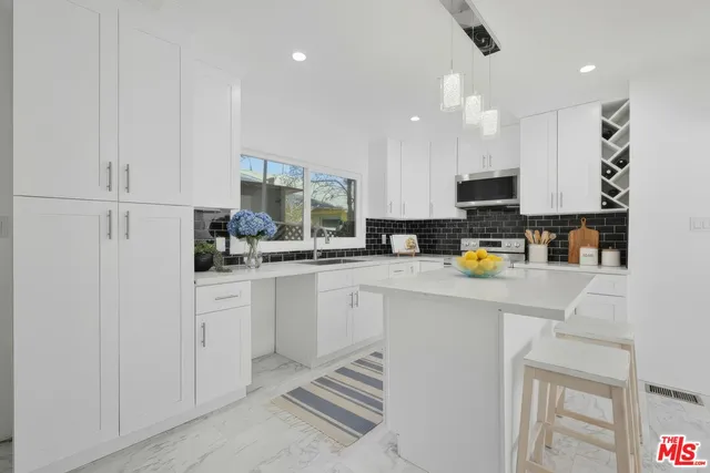 a kitchen with stainless steel appliances a refrigerator sink and cabinets