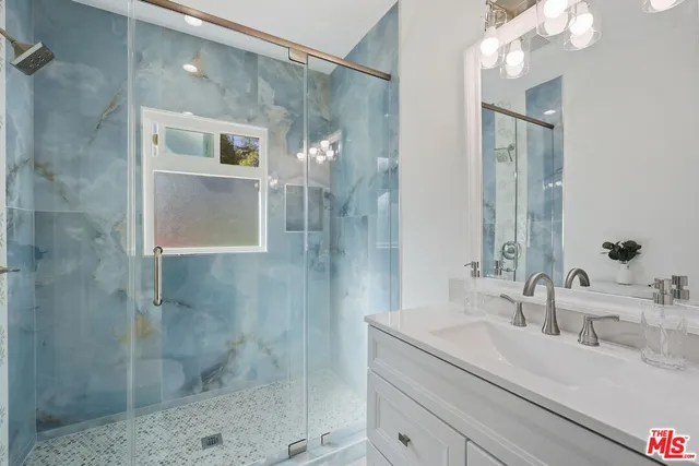 a bathroom with a shower sink and mirror