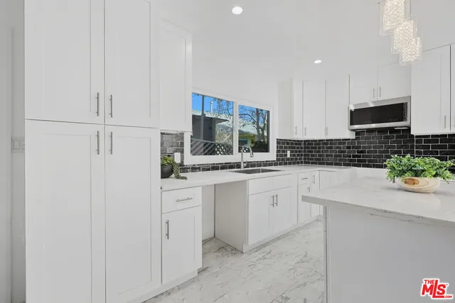 a kitchen with white cabinets and white appliances