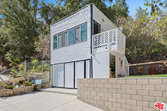 a view of a house with a large window and potted plants