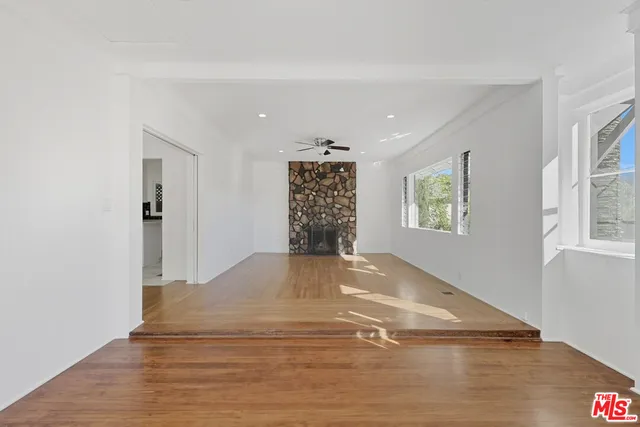 a view of a livingroom with wooden floor and windows