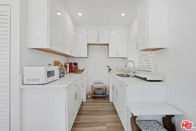 a kitchen with stainless steel appliances granite countertop a lot of cabinets and wooden floor