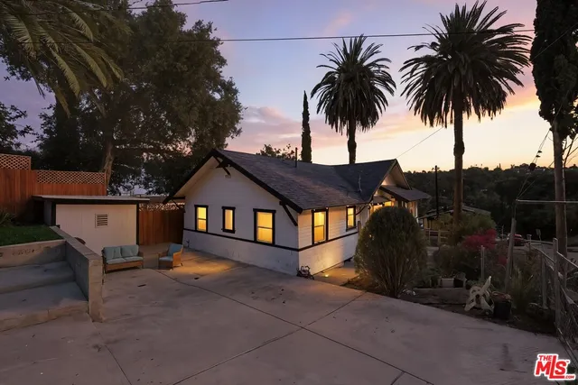 a front view of house with deck and seating space